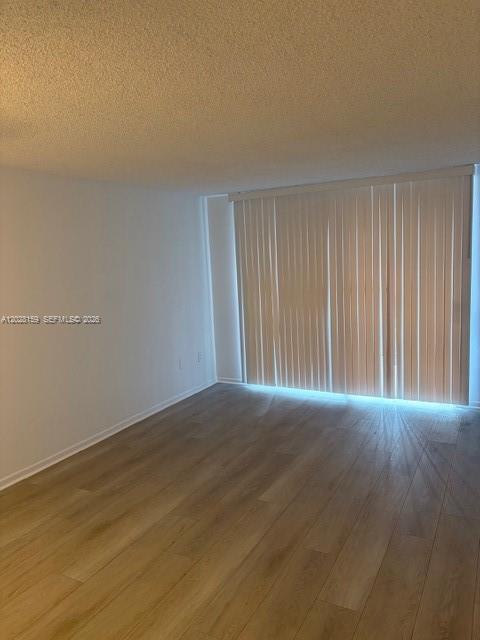 An empty room features light wood-look flooring, white walls, and floor-to-ceiling vertical blinds — 9460 Fontainebleau Blvd # 529, Miami FL 33172, MIAMI, FL