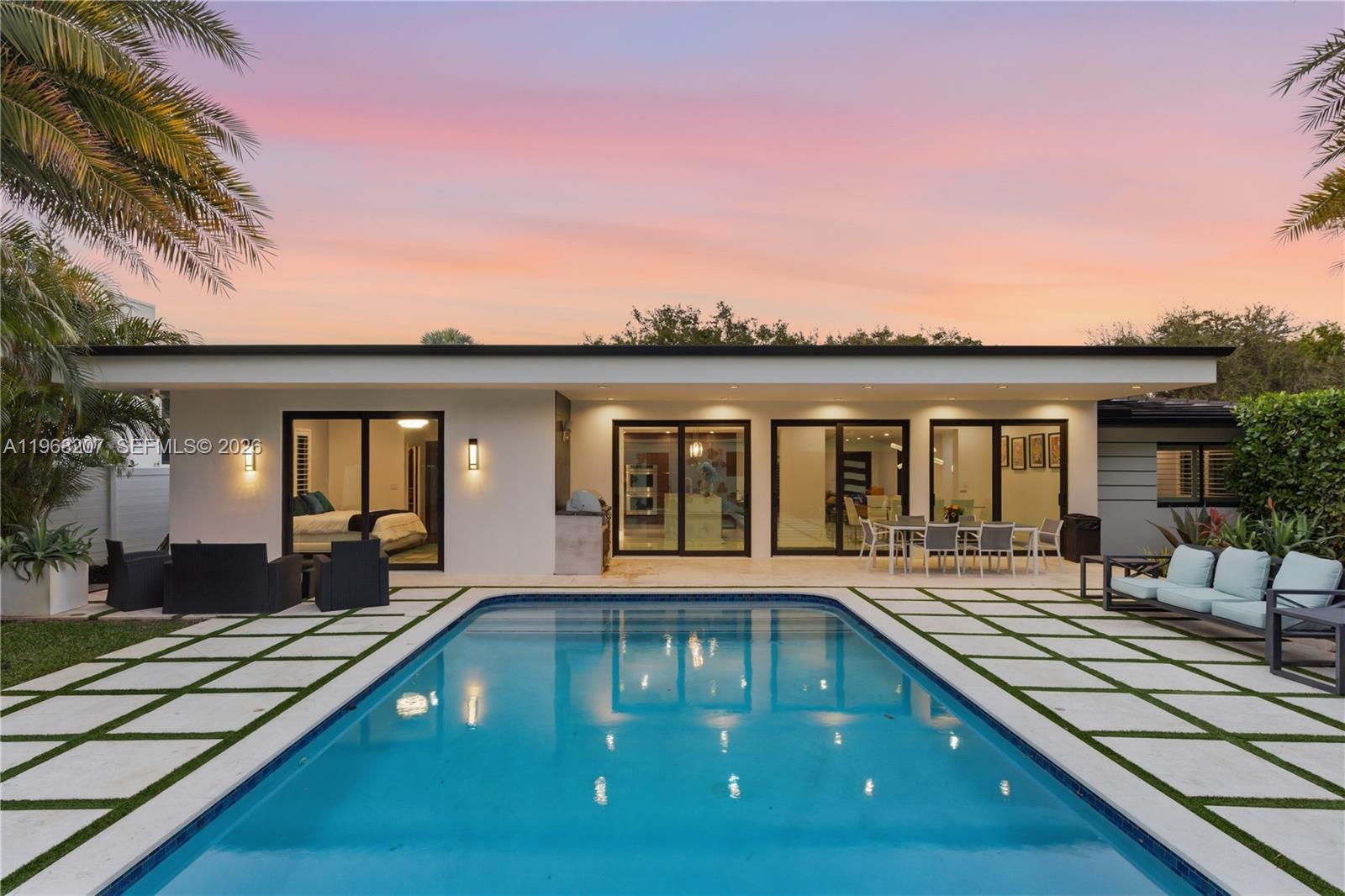A modern house exterior features a swimming pool, patio, and large sliding glass doors — 400 NW 24th St, Wilton Manors FL 33311, WILTON MANORS, FL