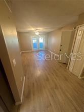 An interior view of a living area featuring light wood-look flooring and sliding glass doors — 904 LAKE DESTINY ROAD UNIT H, ALTAMONTE SPRINGS, FL
