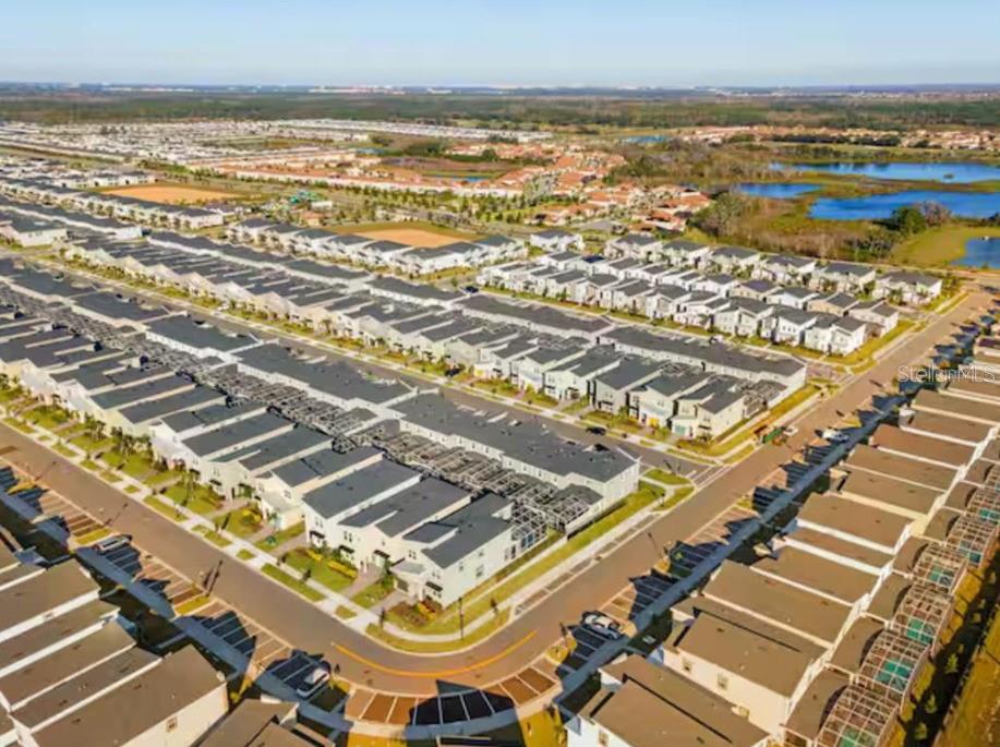 An aerial view of a suburban neighborhood featuring rows of townhomes with screened-in lanais — 1184 KINGSBARN STREET, DAVENPORT, FL