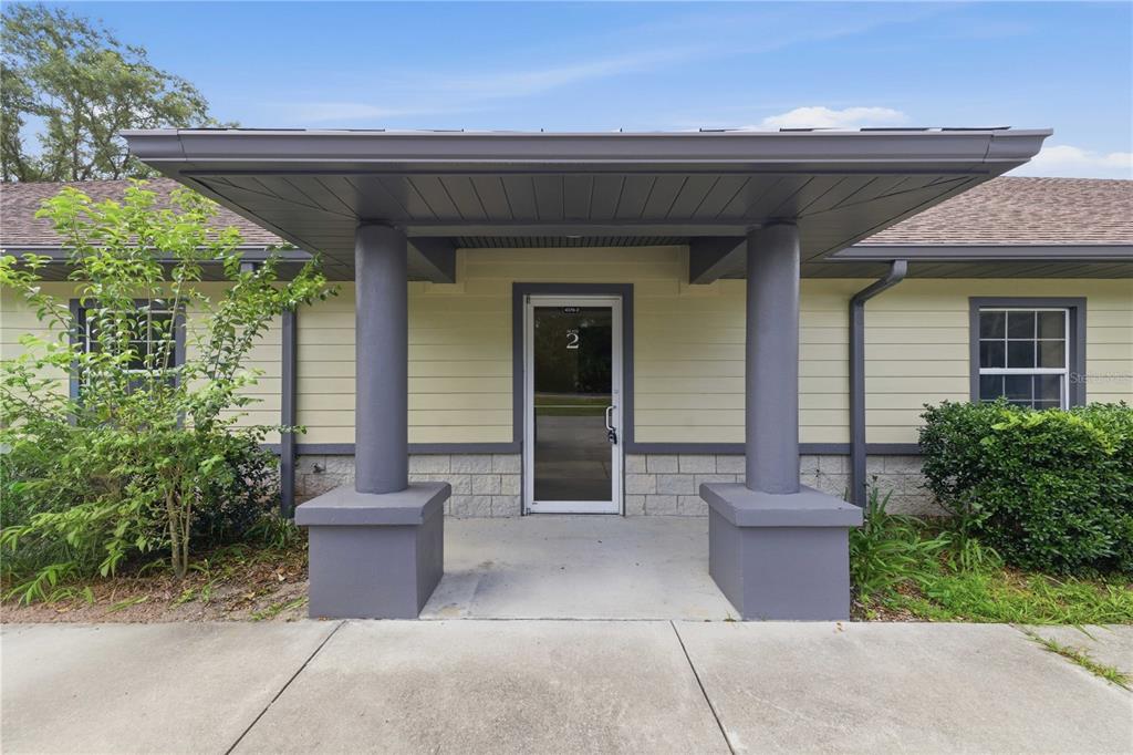 The exterior of a building features a covered entryway with two gray pillars and a door — 4370 NE 35TH STREET UNIT 2, OCALA, FL