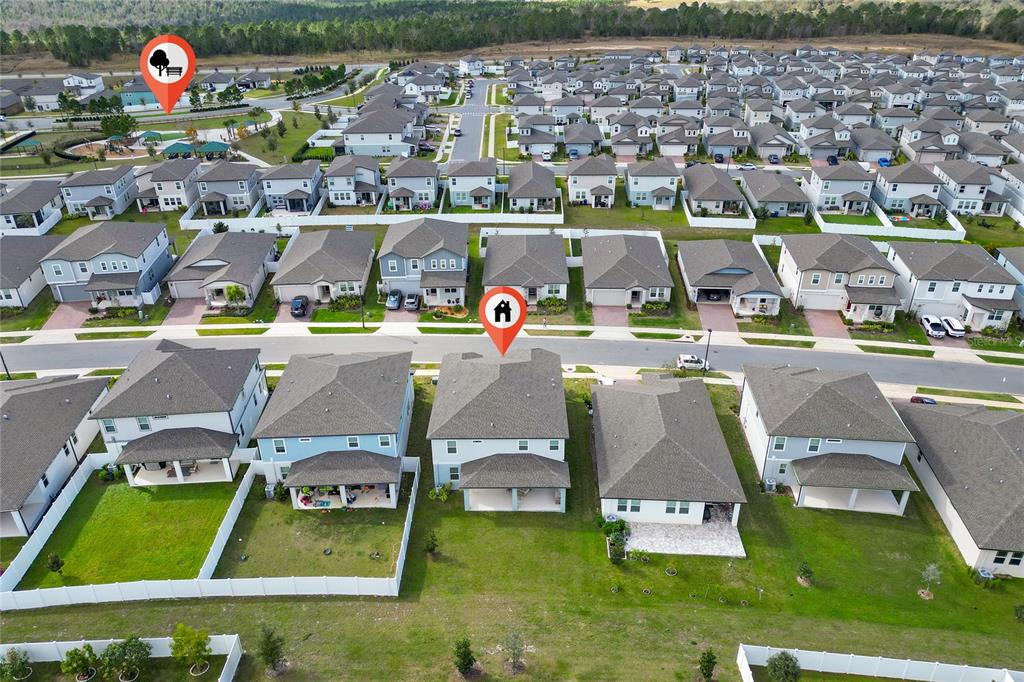 An aerial view shows a suburban neighborhood with rows of houses and a park area — 2284 BEAR PEAK ROAD, CLERMONT, FL