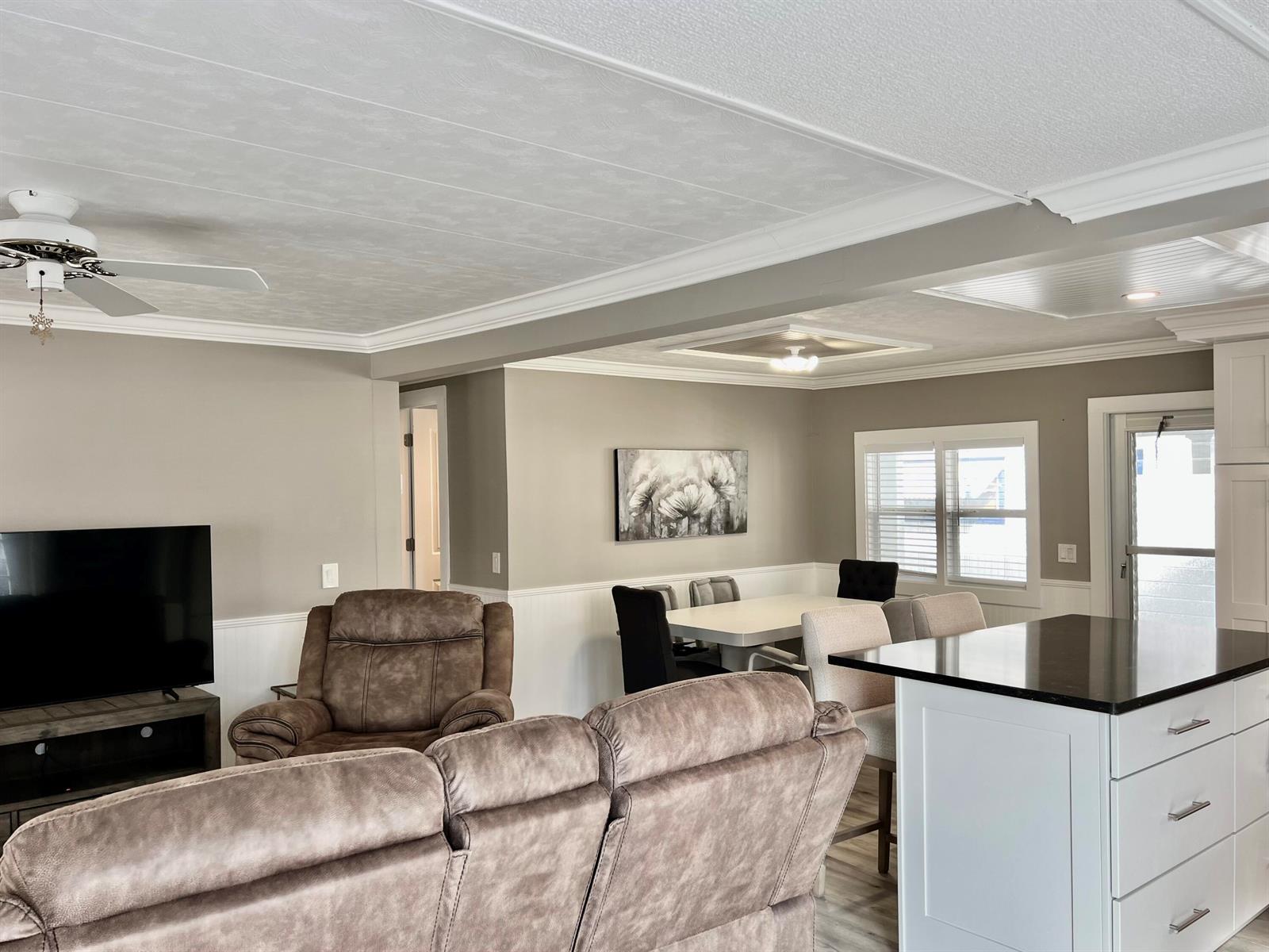 An open-concept living and dining area features neutral walls, white wainscoting, and a kitchen island — 1554 S 33rd Road, Hollywood FL 33021, HOLLYWOOD, FL