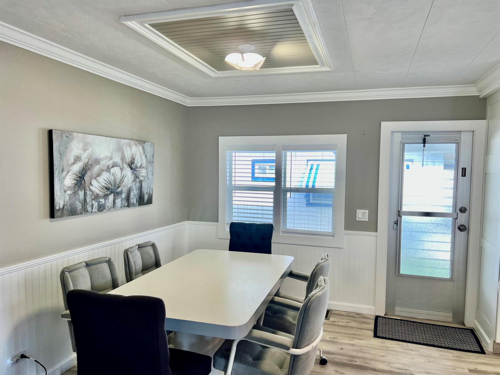 A dining room features a white table, grey chairs, beadboard wainscoting, and a ceiling light — 1554 S 33rd Road, Hollywood FL 33021, HOLLYWOOD, FL