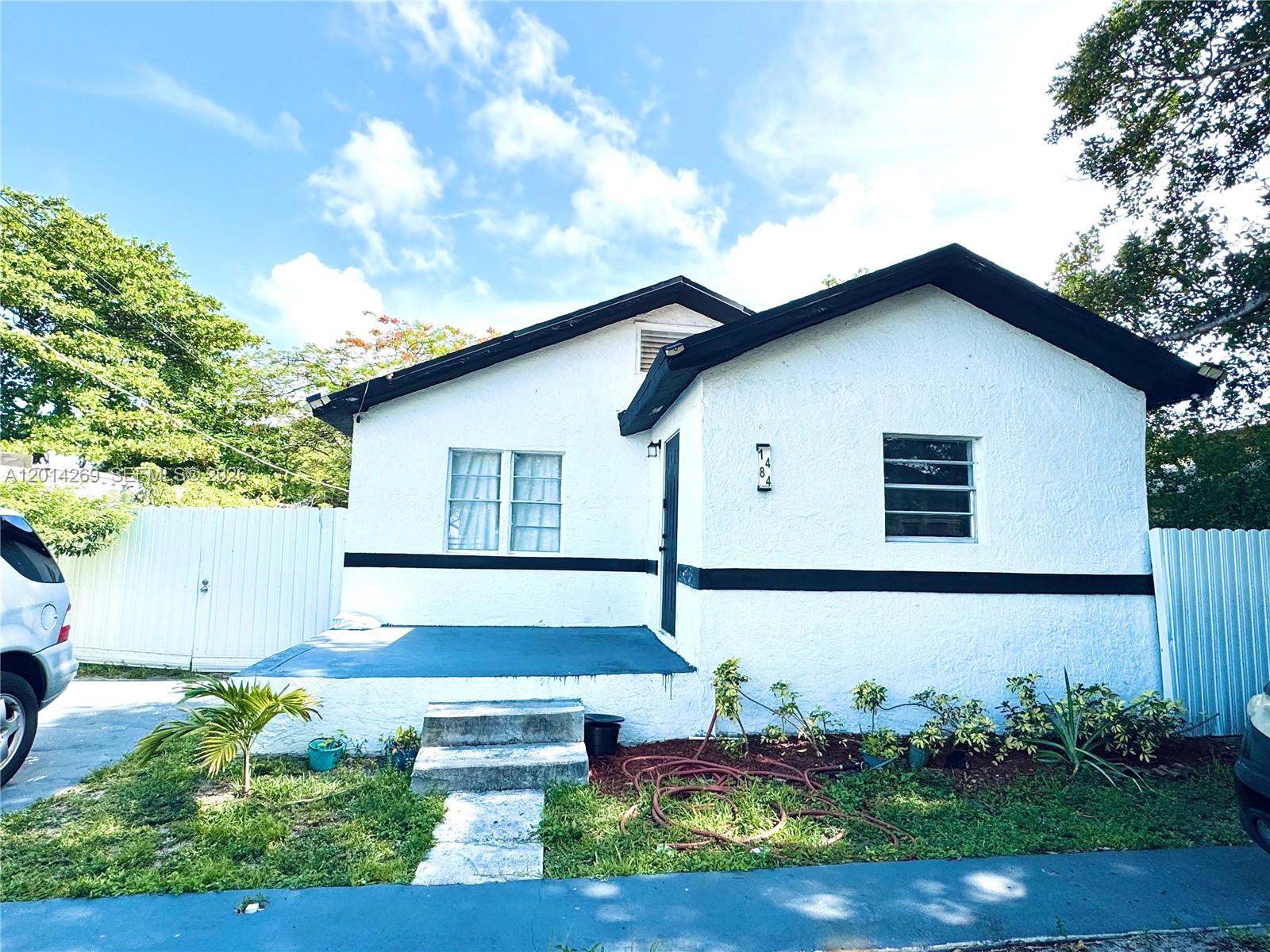 A white, single-story house with a black trim and a small front porch — 1484 NW 60th St, Miami FL 33142, MIAMI, FL