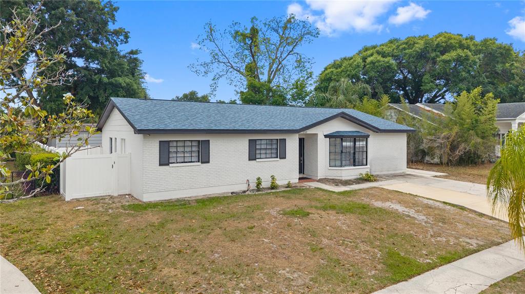 A single-story white brick house with a dark shingled roof and a front lawn — 2310 W KNOLLWOOD PLACE, TAMPA, FL