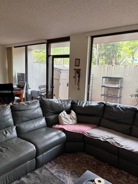 A living room features a large gray sectional sofa facing floor-to-ceiling windows and doors — 3190 Bird Ave # 15, Coconut Grove FL 33133, COCONUT GROVE, FL