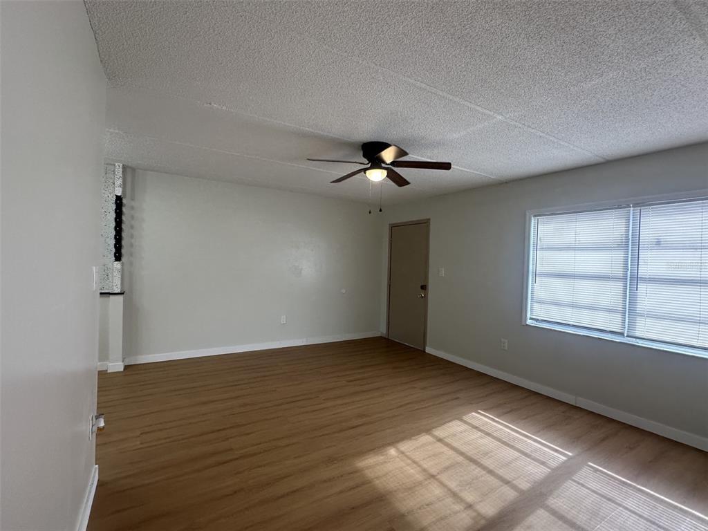 A dining area with wood-look flooring, a modern light fixture, and a sliding glass door — 1912 HONOUR ROAD UNIT 1, ORLANDO, FL