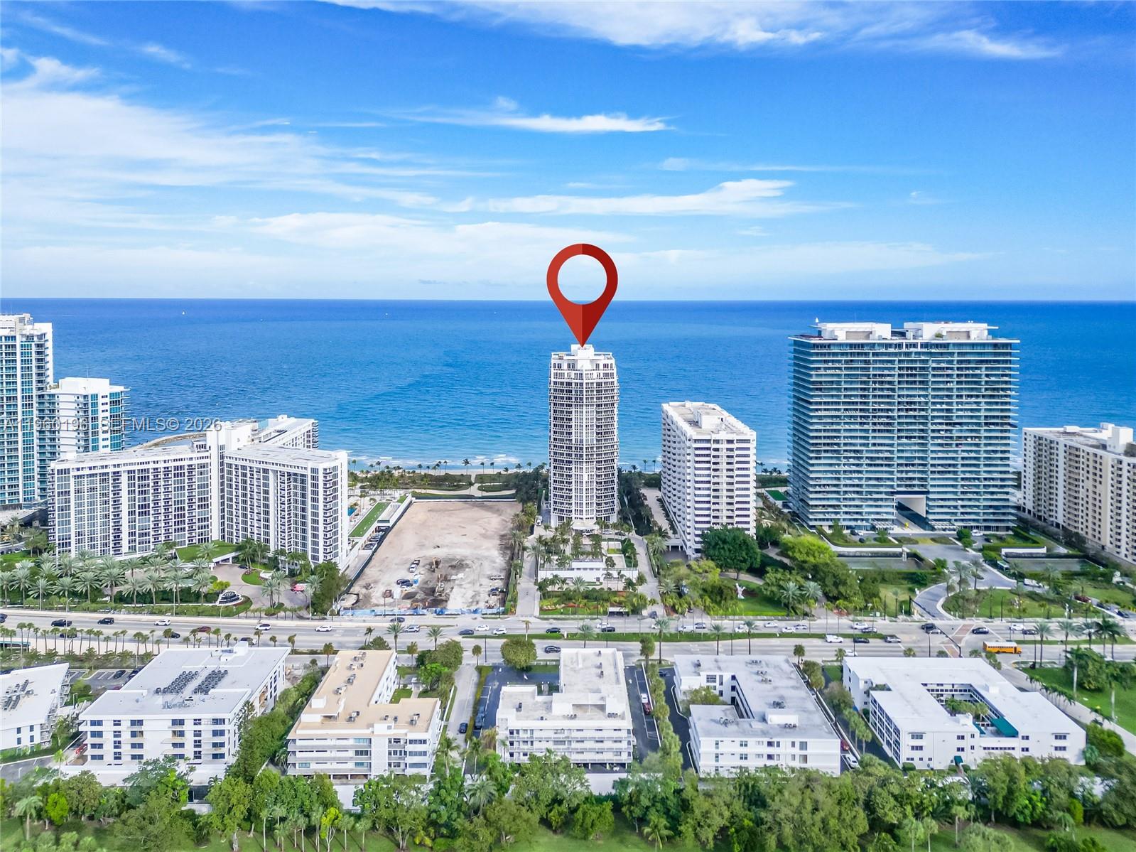 An aerial view shows a tall, cylindrical residential building on a beach with surrounding properties — 10225 Collins Ave # 304, Bal Harbour FL 33154, BAL HARBOUR, FL