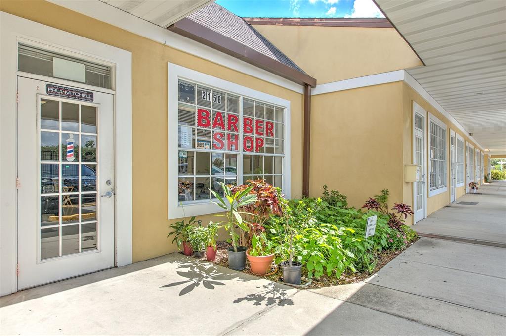 The exterior of a commercial storefront features a white door and a large windowed sign — 2156 CO RD 540A, LAKELAND, FL