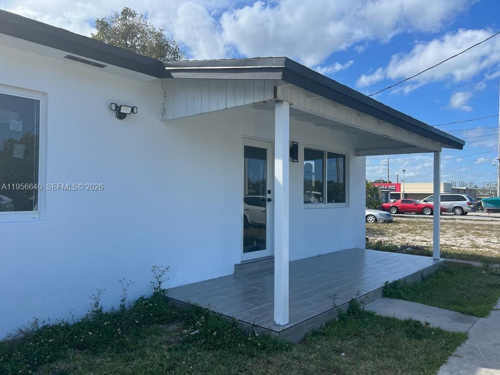A white building with a covered porch, tiled floor, and a glass-paneled front door — 1013 NW 1st Ave, Hallandale Beach FL 33009, HALLANDALE BEACH, FL