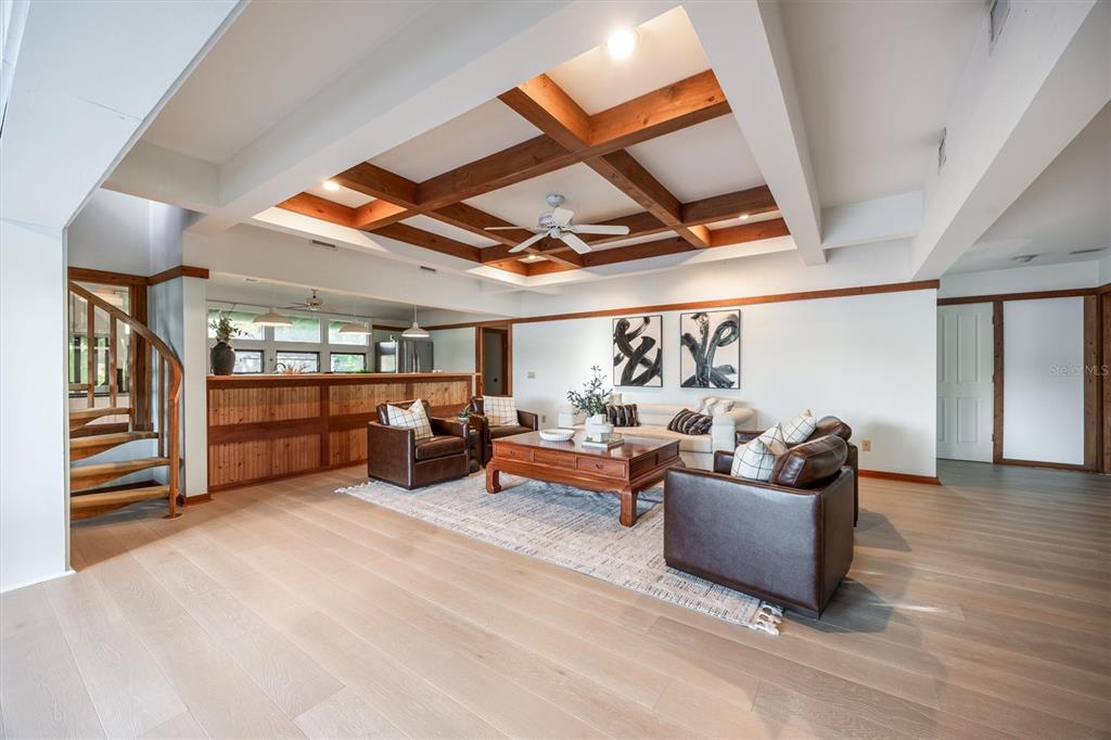 A living room features a coffered wood ceiling, leather armchairs, and a spiral staircase — 25608 DEVONIA STREET, MELROSE, FL