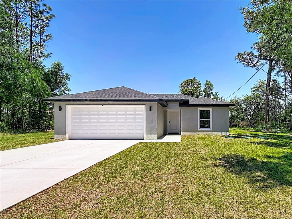 A single-story house with a white garage door, gray stucco exterior, and a concrete driveway — 6 CEDAR TRACE COURT, OCALA, FL