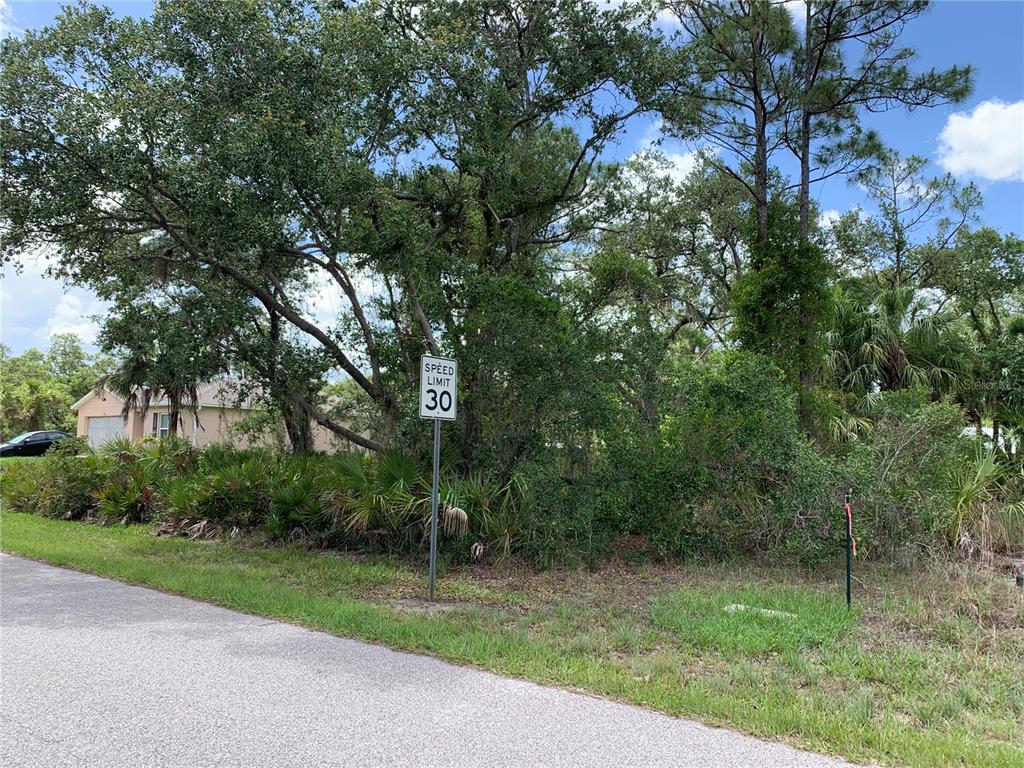A speed limit sign stands in front of a wooded lot next to a house — 17496 BILLIAR AVENUE, PORT CHARLOTTE, FL