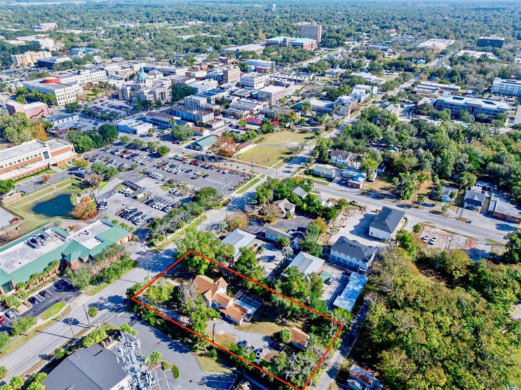An aerial view shows a residential property outlined in red within a suburban city setting — 228 W HOWRY AVENUE, DELAND, FL