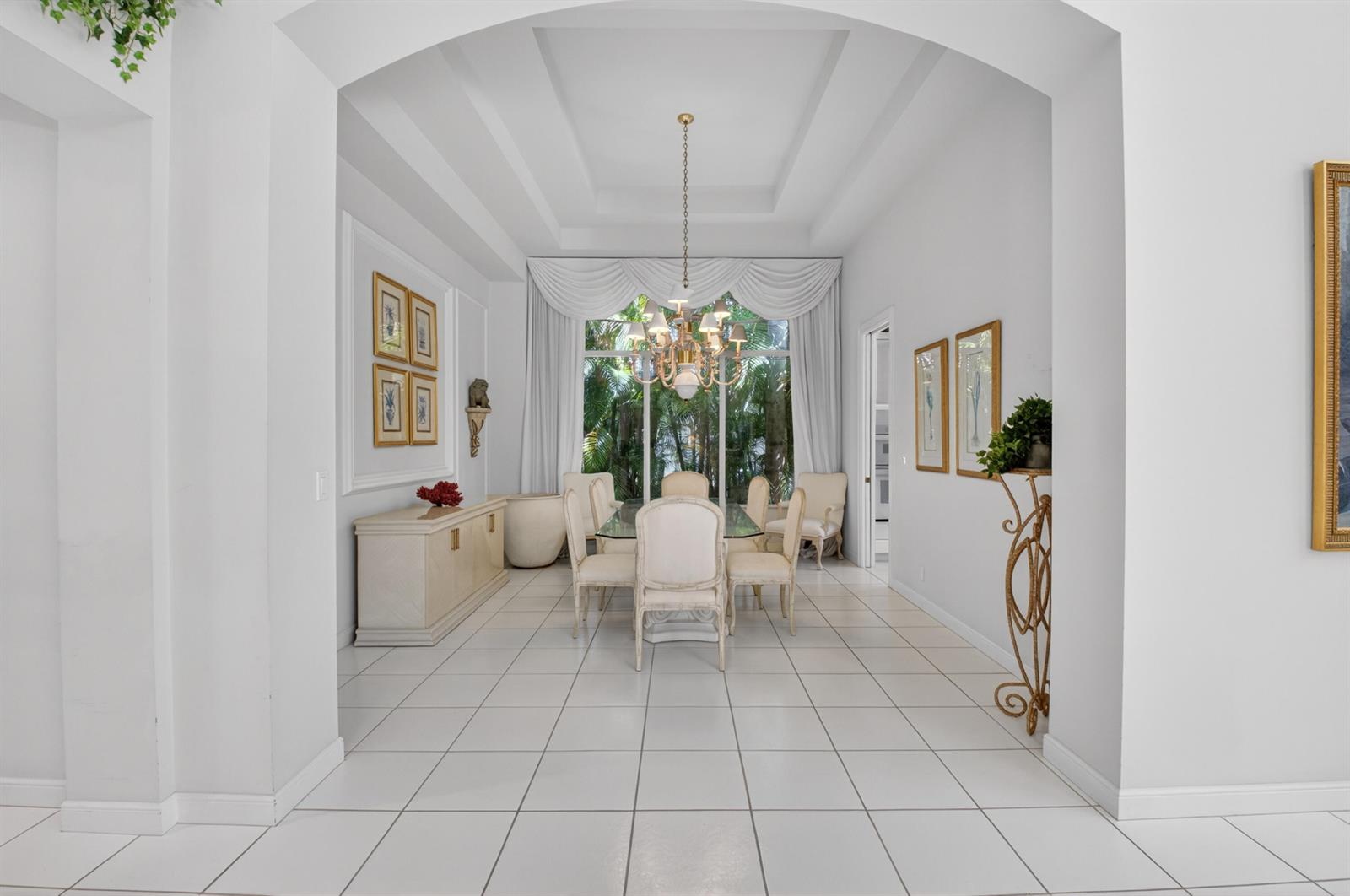 A formal dining room features white tile floors, a coffered ceiling, and a glass table — 21650 Frontenac Court, Boca Raton FL 33433, BOCA RATON, FL
