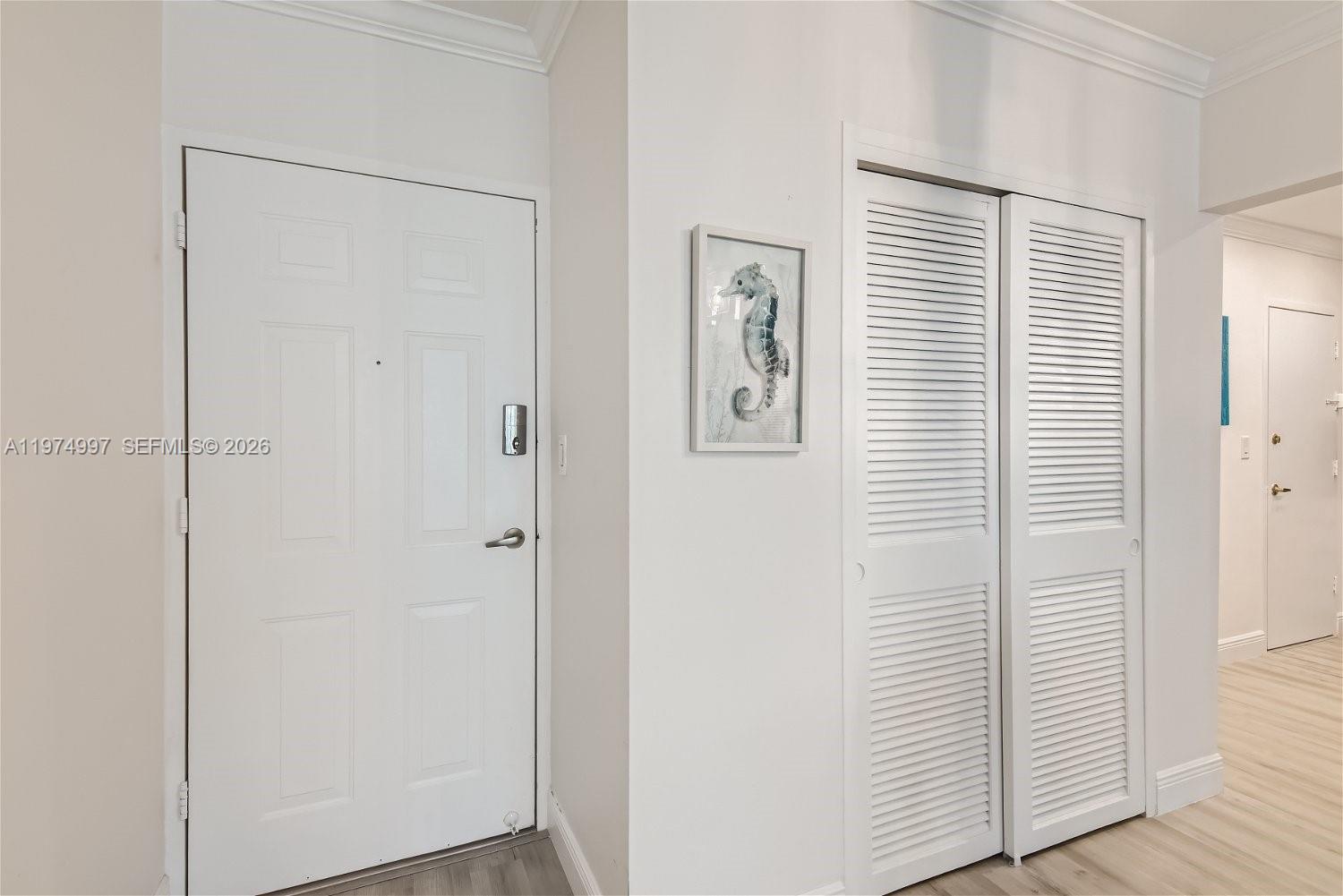 A white front door sits next to a white louvered closet door in an entryway — 2501 S Ocean Dr, Hollywood FL 33019, HOLLYWOOD, FL