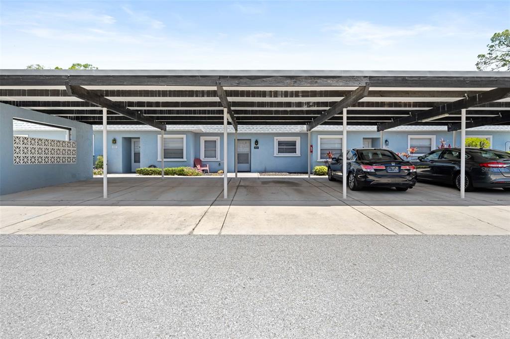 A covered carport area sits in front of a blue single-story residential building — 3534 TEESIDE DRIVE, NEW PORT RICHEY, FL