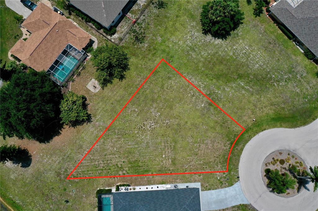 An aerial view shows a vacant, irregularly shaped residential lot outlined in red — 204 YELLOW ELDER, PUNTA GORDA, FL