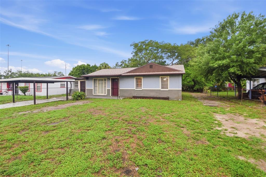 A single-story house with a gray brick exterior, a brown roof, and a carport — 3008 N 43RD STREET, TAMPA, FL