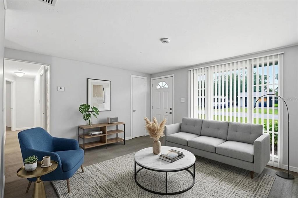 A living room features a grey sofa, a blue armchair, and a round marble coffee table — 3008 N 43RD STREET, TAMPA, FL