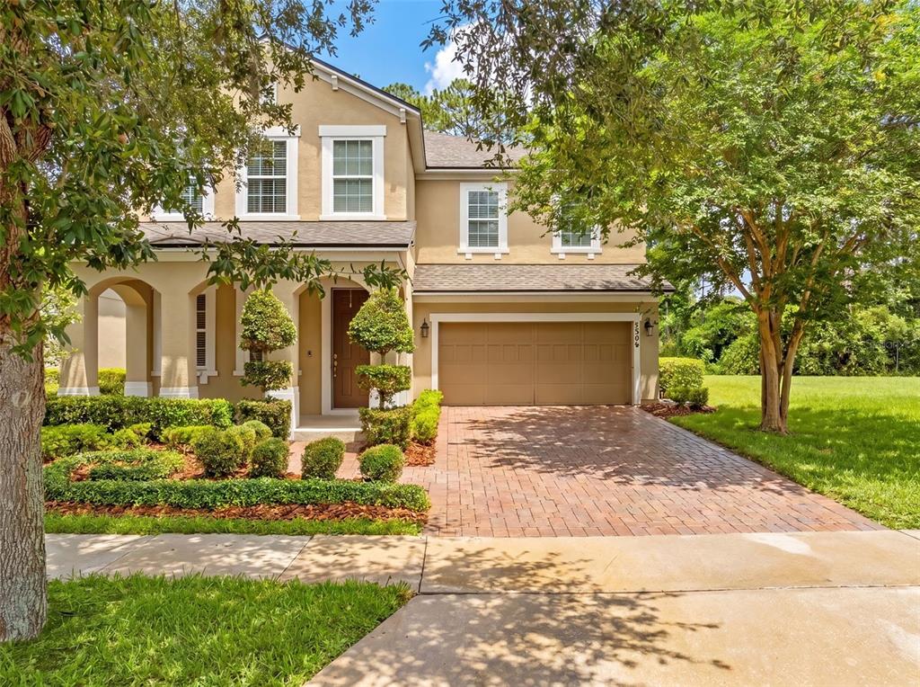 A two-story tan house with a brick paver driveway and a two-car garage — 7906 JAILENE DRIVE, WINDERMERE, FL
