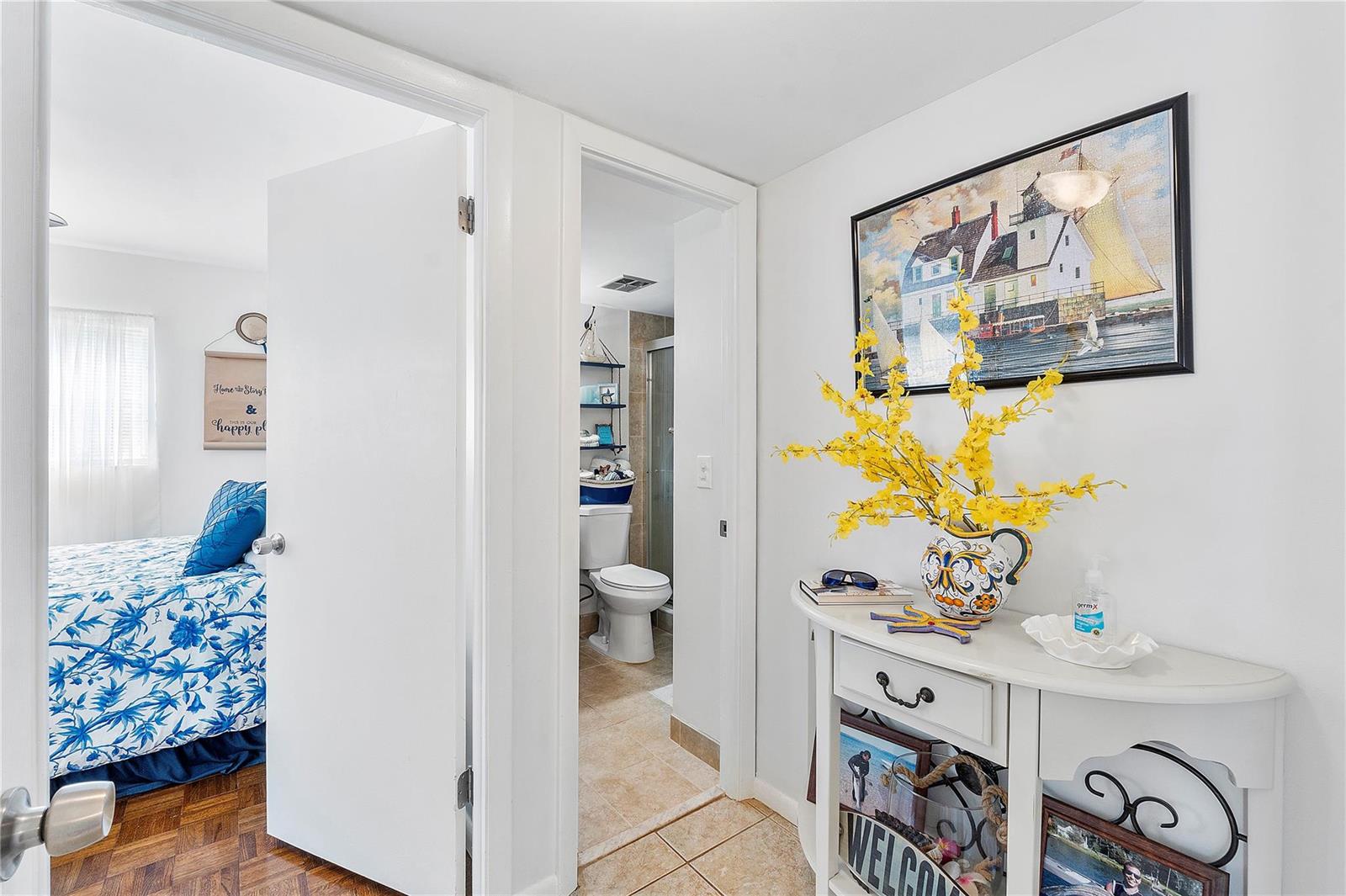 A white hallway leads to a bathroom and a bedroom with blue and white bedding — 441 NW 76th Avenue # 101, Margate FL 33063, MARGATE, FL