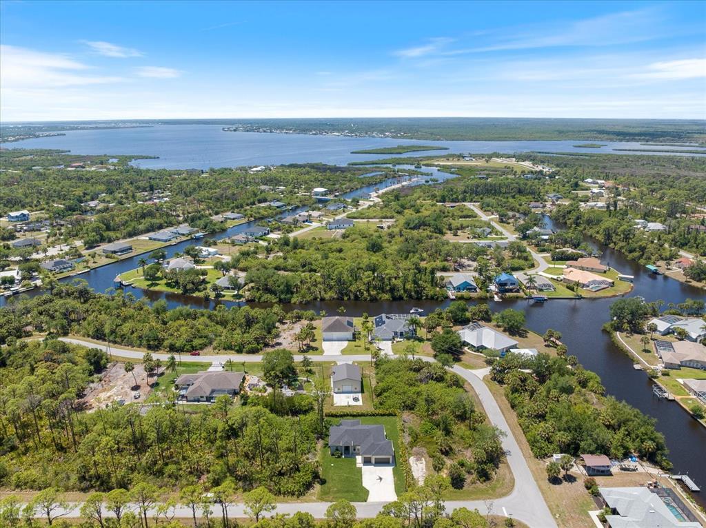 An aerial view shows houses situated along winding canals leading to a large body of water — 12123 FEDERAL AVENUE, PORT CHARLOTTE, FL