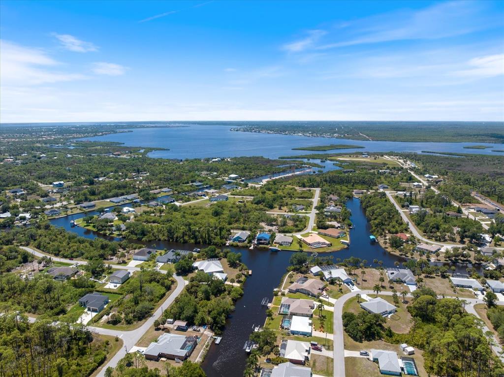 Aerial view of a residential neighborhood with houses situated along a canal leading to water — 12123 FEDERAL AVENUE, PORT CHARLOTTE, FL