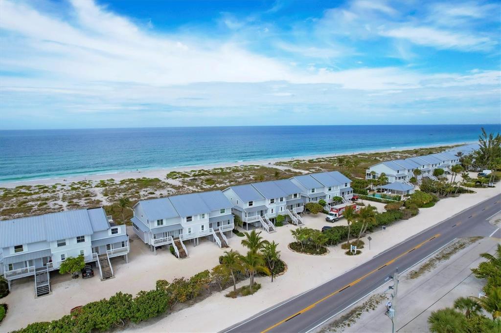 An aerial view shows several elevated beach houses situated between a road and the ocean — 420 GULF BOULEVARD UNIT 20, BOCA GRANDE, FL