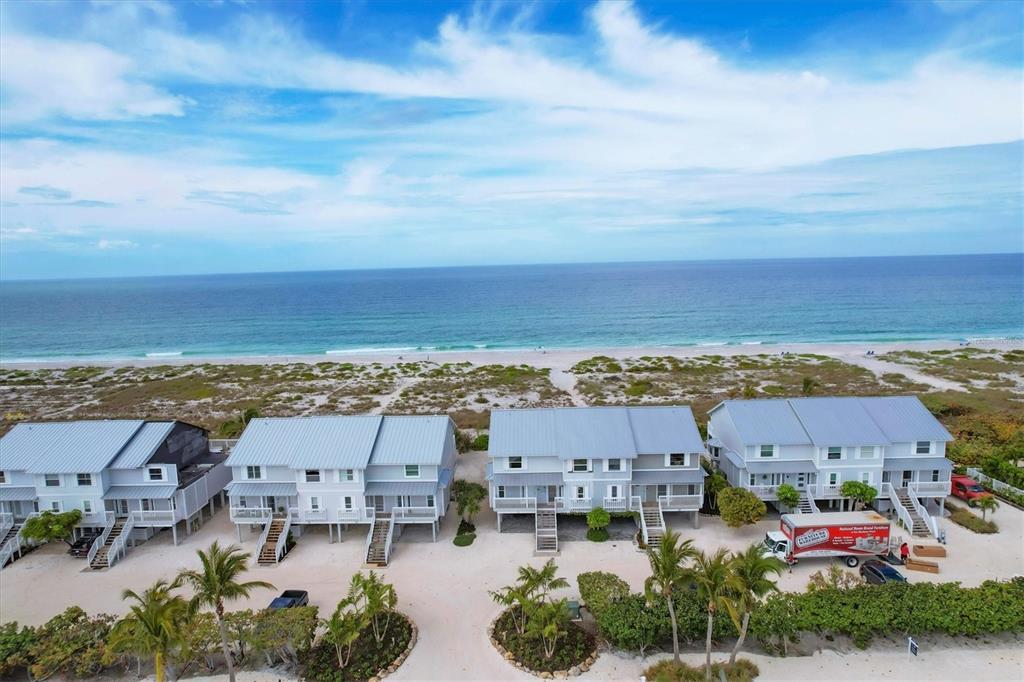 An aerial view shows several beach houses with metal roofs situated near the ocean — 420 GULF BOULEVARD UNIT 20, BOCA GRANDE, FL