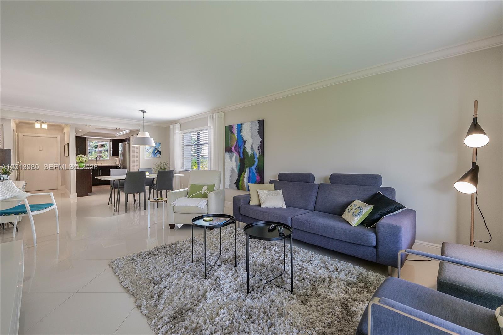 A living room with a blue sofa, two round tables, and a shag area rug — 6200 NW 44th St # 301, Lauderhill FL 33319, LAUDERHILL, FL