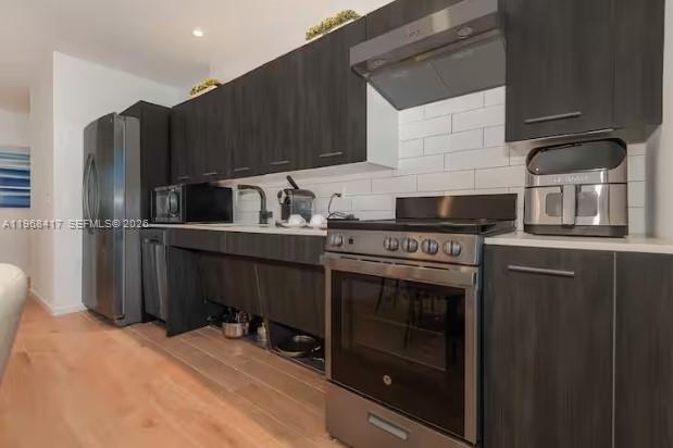 A modern kitchen features dark wood cabinets, stainless steel appliances, and a white subway tile backsplash — 398 NE 5th St # 3511, Miami FL 33132, MIAMI, FL
