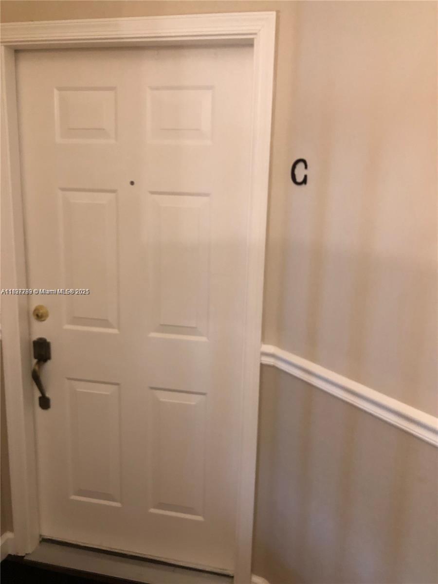 A white door with a black handle is labeled with the letter C on the wall — 5800 Coach House Cir, Boca Raton FL 33486, BOCA RATON, FL