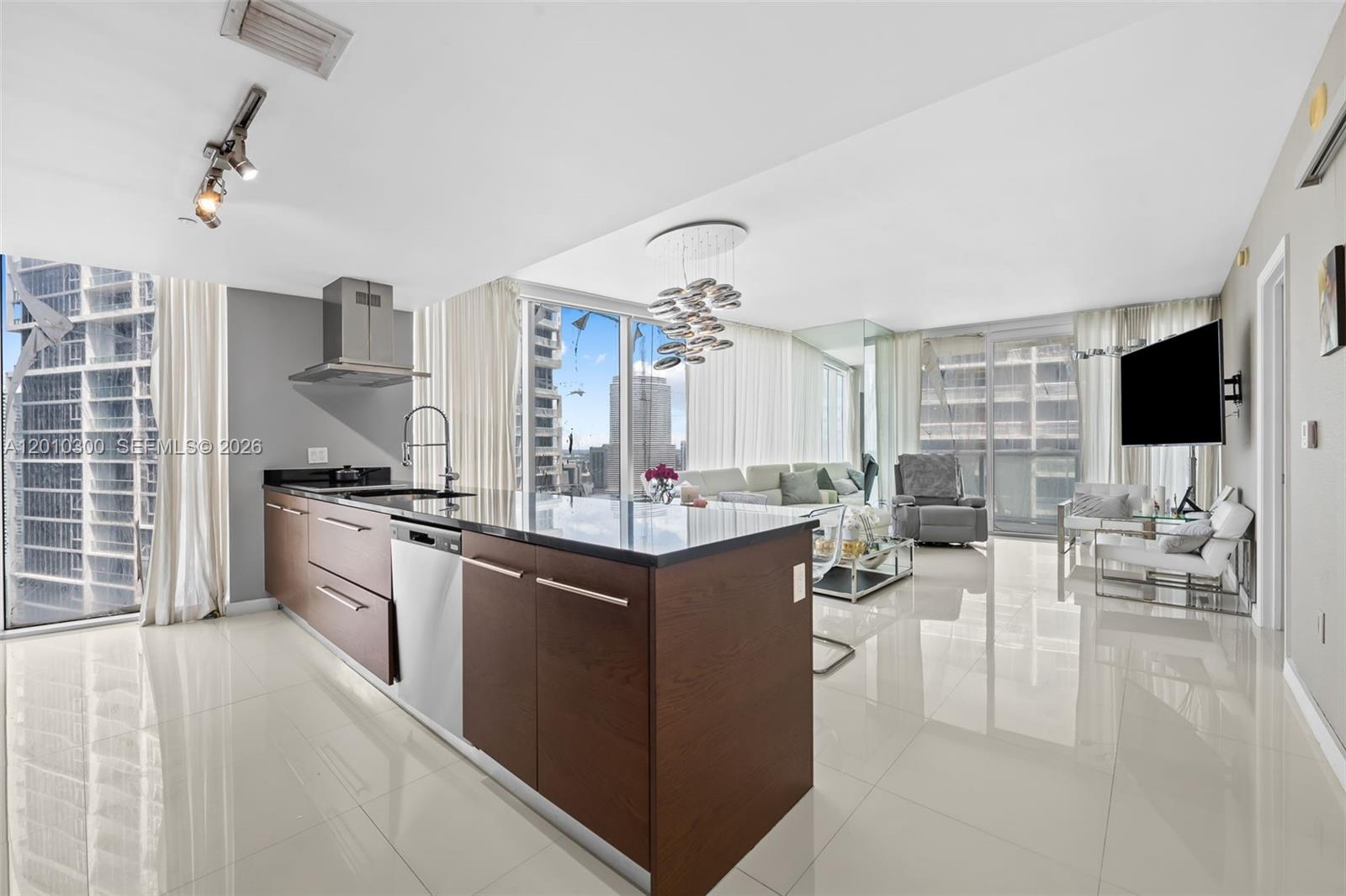 A modern open-concept kitchen and living area with floor-to-ceiling windows and city views — 495 Brickell Ave # 3710, Miami FL 33131, MIAMI, FL