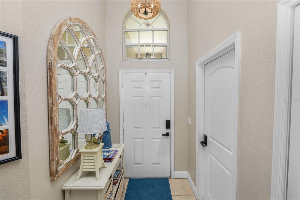 An entryway features a white front door, a tall arched mirror, and a console table — 6201 VINTAGE DRIVE, LAKELAND, FL