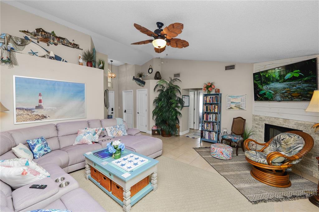 A living room features a sectional sofa, a coffee table, a fireplace, and coastal decor — 6201 VINTAGE DRIVE, LAKELAND, FL
