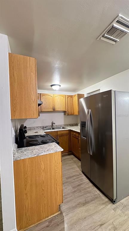 A kitchen features wood cabinets, stainless steel appliances, and light-colored countertops — 3775 SW 147TH LANE ROAD, OCALA, FL
