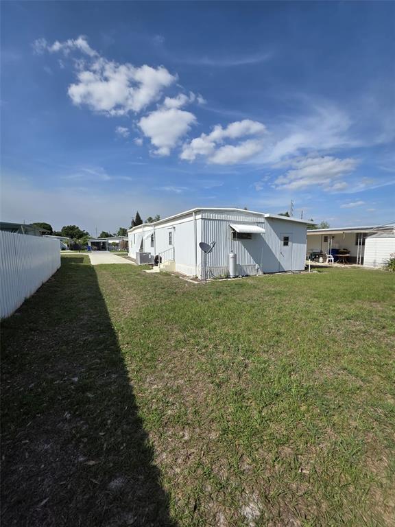 A light-colored mobile home sits on a grassy lot under a bright blue sky — 3217 ILLINOIS AVENUE, SEBRING, FL