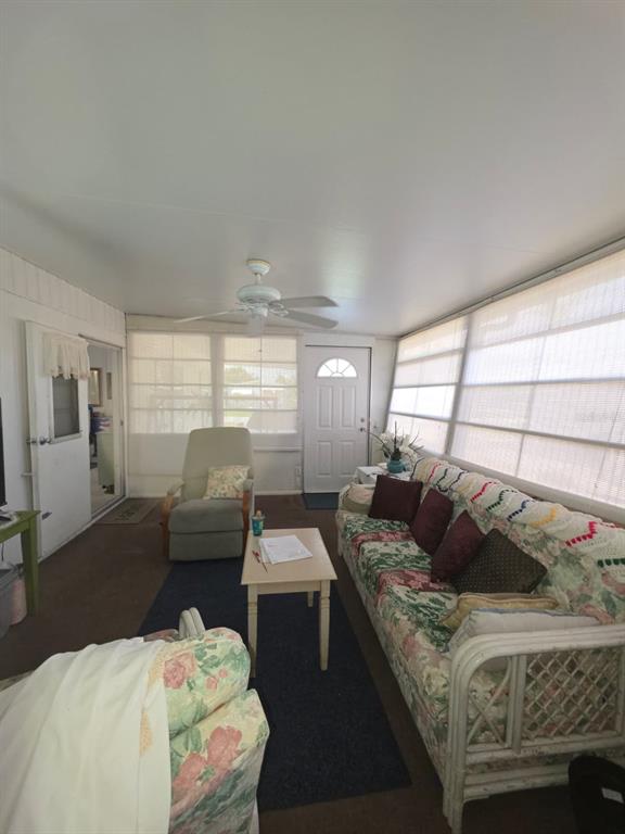 A sunroom features a ceiling fan, a floral sofa, a recliner, and large windows — 3217 ILLINOIS AVENUE, SEBRING, FL
