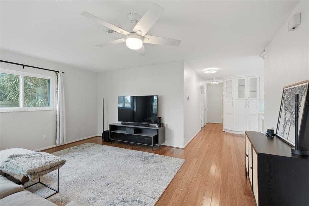 A living room features a ceiling fan, a television on a stand, and hardwood floors — 205 SE MONROE CIRCLE N, ST PETERSBURG, FL