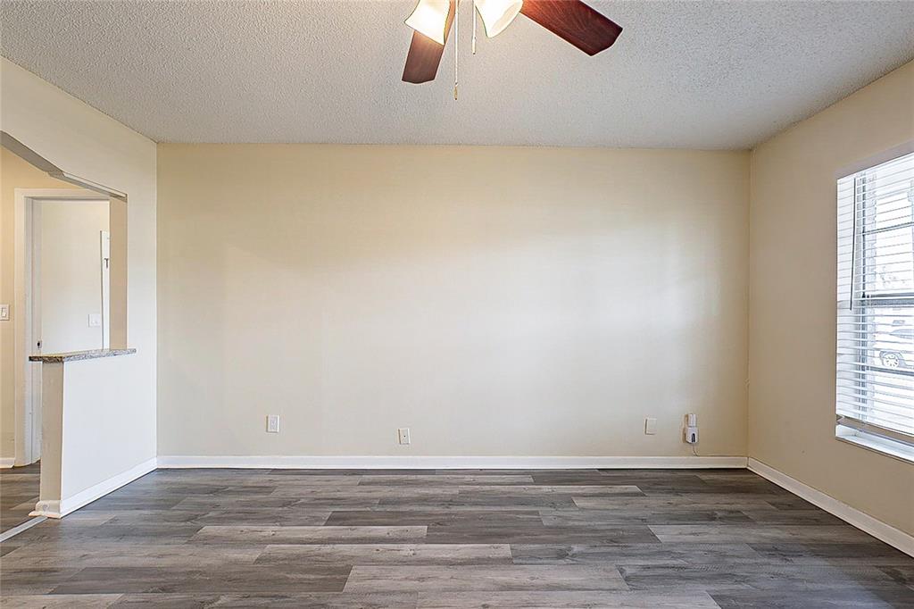 An empty room with beige walls, wood-look flooring, a ceiling fan, and a window — 8528 GOLD RIDGE CIRCLE, TAMPA, FL
