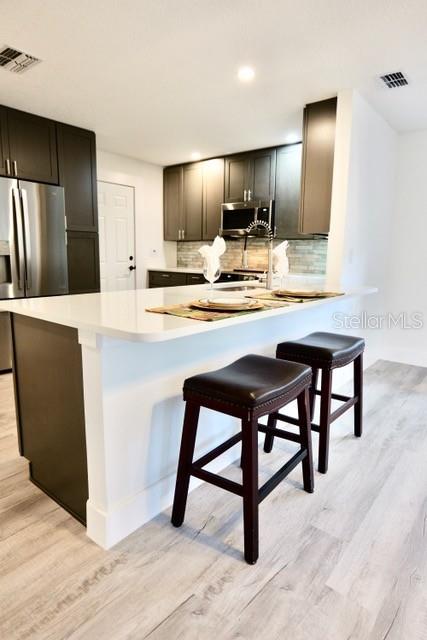 A kitchen features dark cabinets, a white quartz island, and two dark leather bar stools — 9120 SW 210TH CIRCLE, DUNNELLON, FL