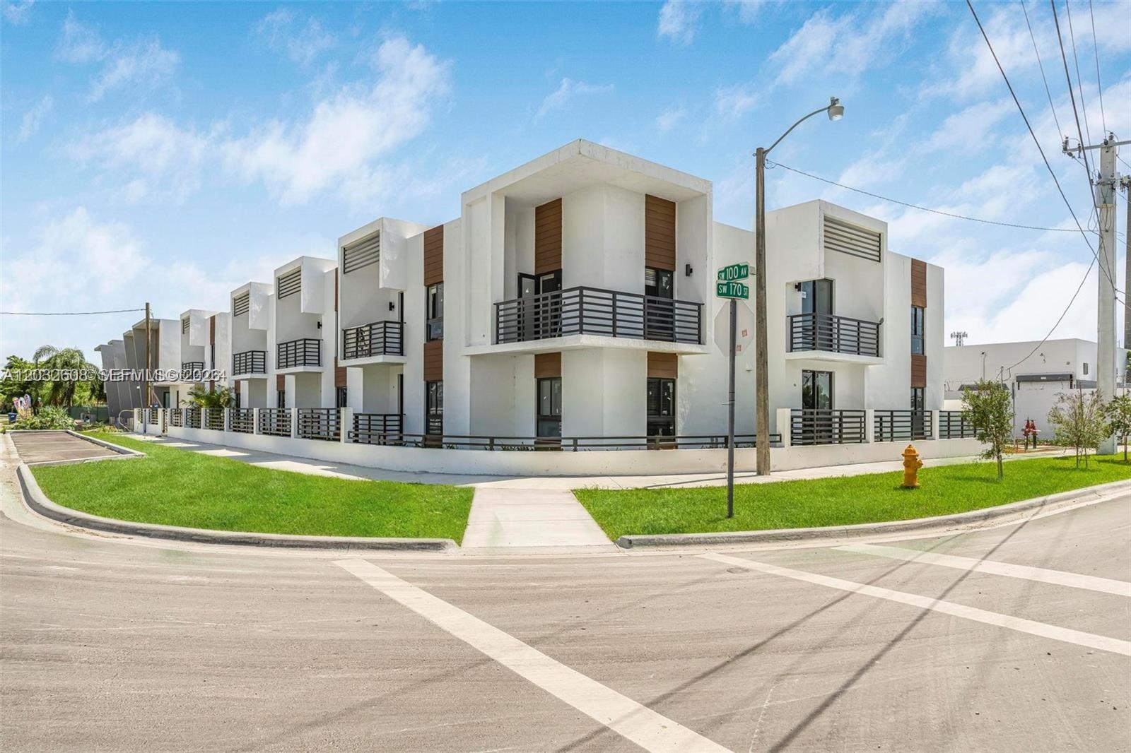 A modern multi-unit residential building with white stucco walls, wood accents, and black metal balconies — 16955 SW 100th Ave # 1, Miami FL 33157, MIAMI, FL