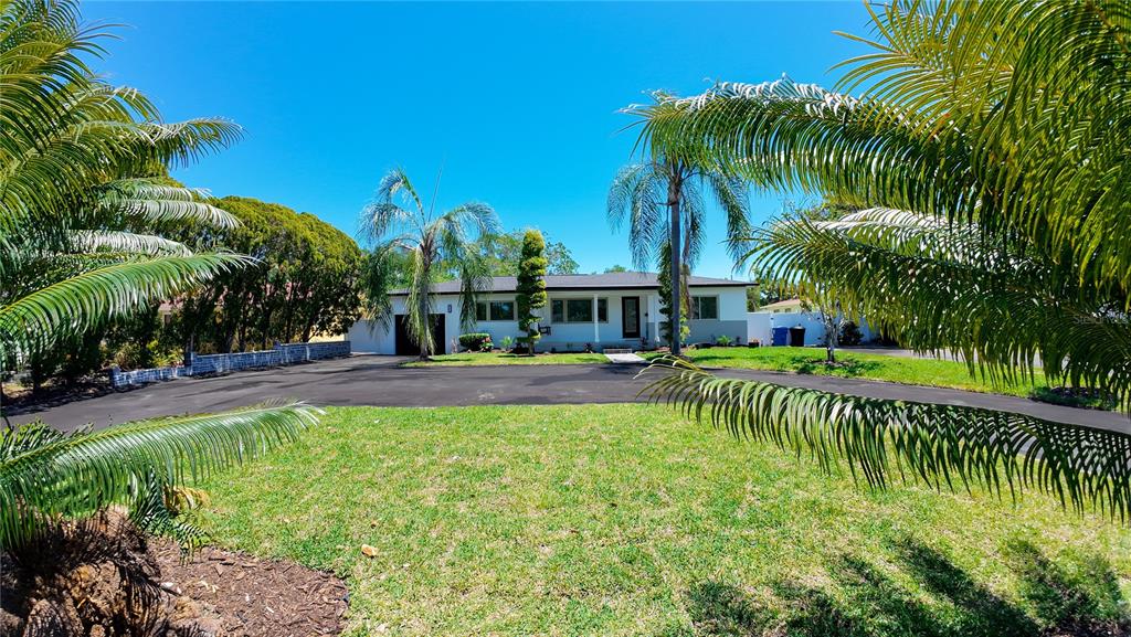 A single-story house with a large asphalt driveway and palm trees in the front yard — 936 ALCAZAR WAY S, ST PETERSBURG, FL