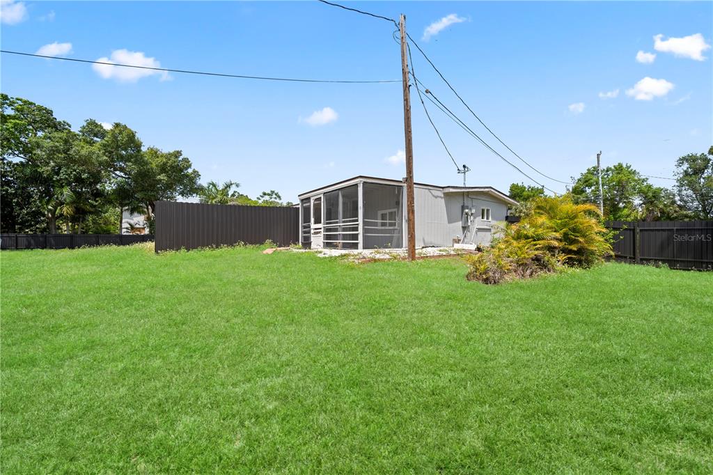 A backyard view shows a small house with a screened-in porch and a dark fence — 1507 LAVILLA ROAD, PUNTA GORDA, FL