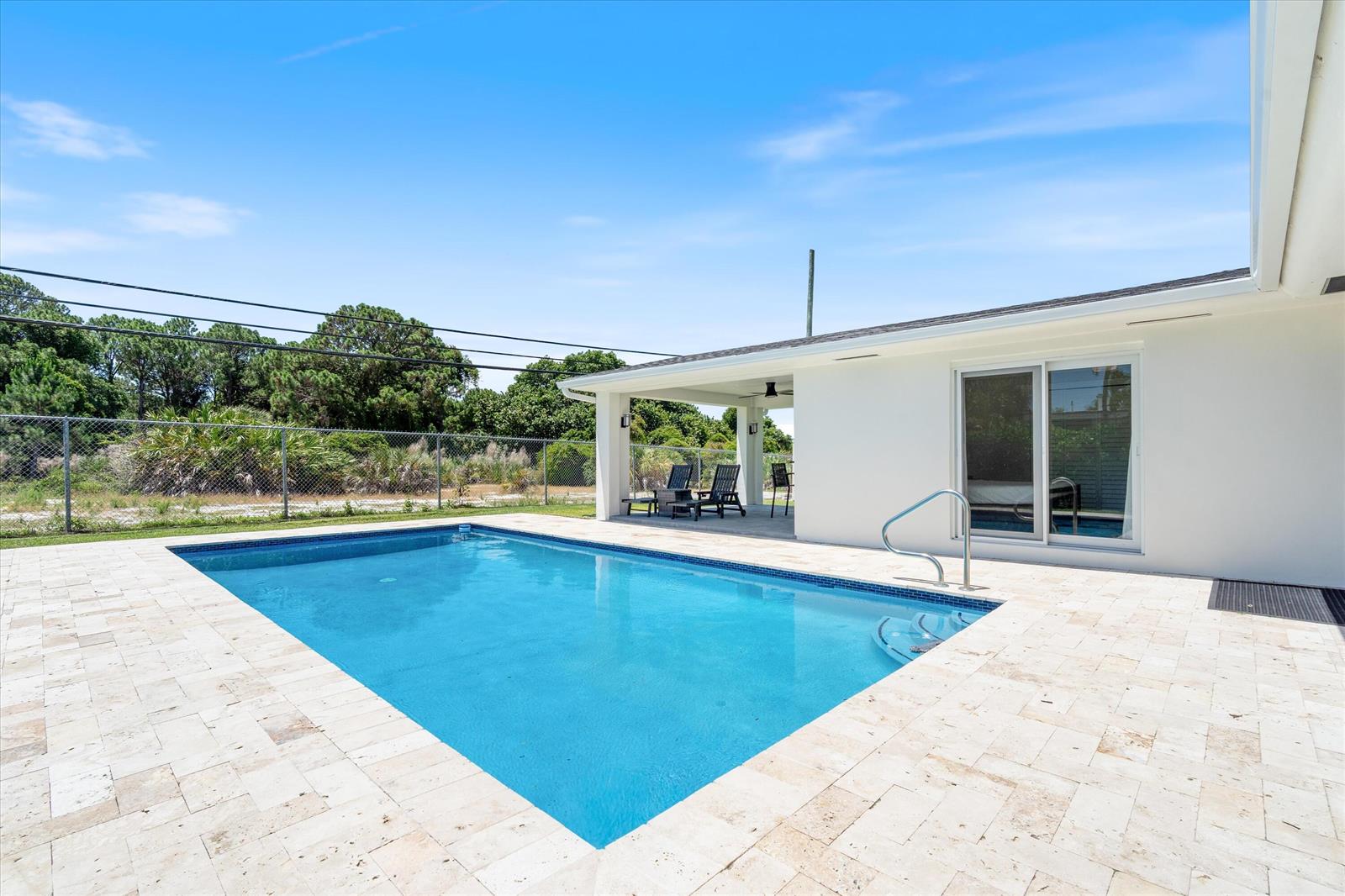A rectangular swimming pool sits on a stone patio next to a white house exterior — 108 SE 31st Avenue, Boynton Beach FL 33435, BOYNTON BEACH, FL