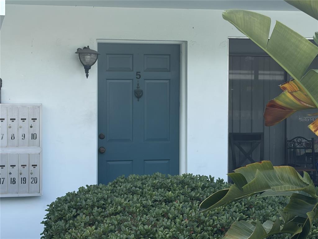 A teal front door labeled number five is positioned next to a set of mailboxes — 1485 LAKEVIEW ROAD UNIT 5, CLEARWATER, FL