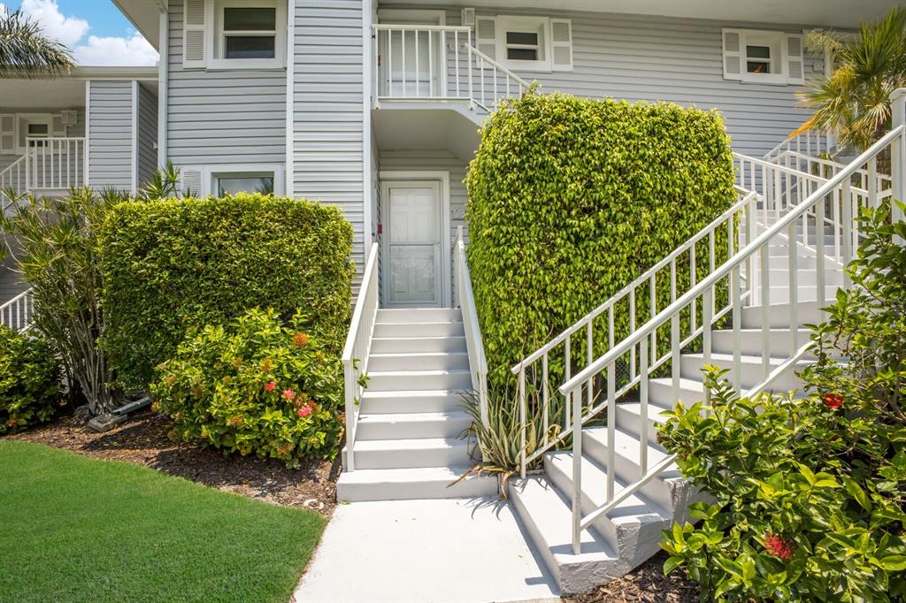 A white exterior staircase leads to the front door of a two-story residential building — 5850 GASPARILLA ROAD UNIT M1&3, BOCA GRANDE, FL