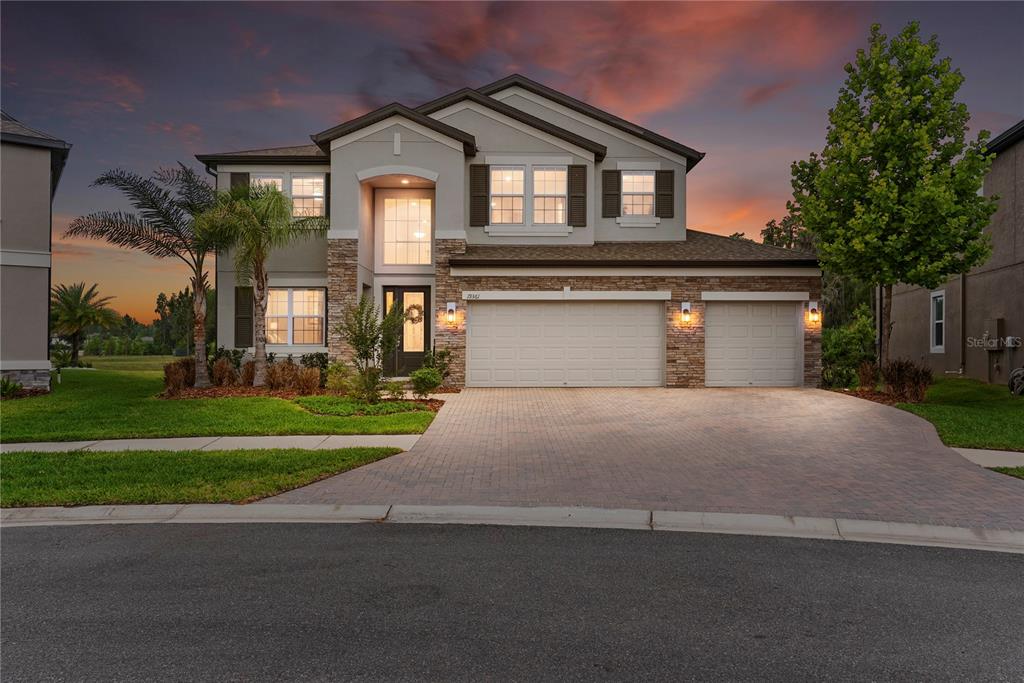 A two-story suburban house with a stone facade, three-car garage, and a paved driveway — 19361 EAGLE CREEK LANE, TAMPA, FL